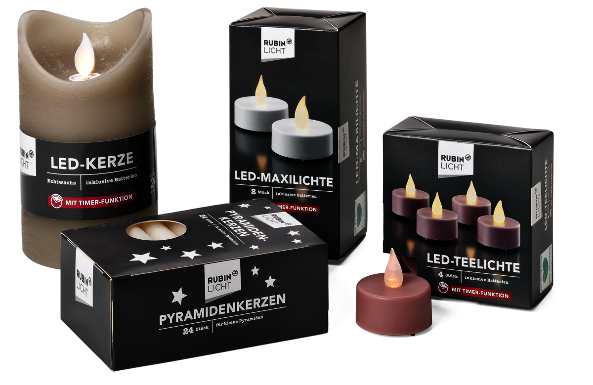 Foto von 4 Produktverpackungen der Rossmann-Marke RubinLicht. Zu sehen sind eine LED-Kerze, LED-Maxilichte, Pyramidenkerzen und LED-Teelichte. Ein lilafarbenes LED-Teelicht steht vor den Verpackungen.